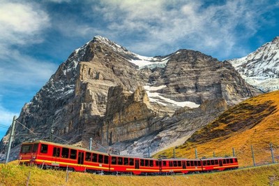 Wandbild: Famous express electric red tourist train coming down from the [...]