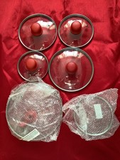 Set of 6 glass saucepan lids with red handles.