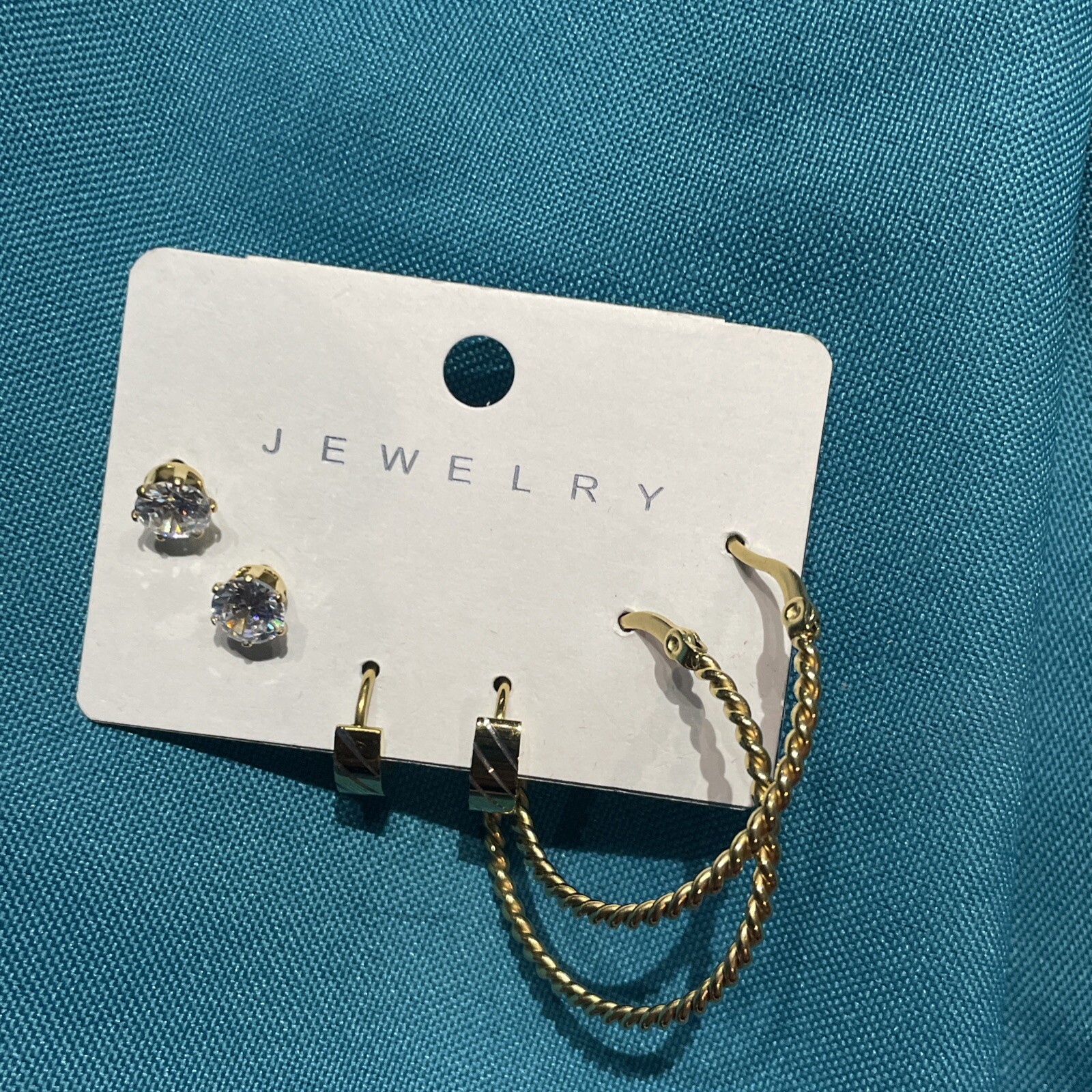 Elegant gold earrings set with crystal studs, gypsy hoops, and wedding band-image