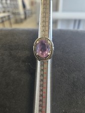 vintage sterling silver ring featuring an oval-cut amethyst gemstone.