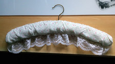 Decorative Padded Hanger . White with pink and green pattern. lace to bottom
