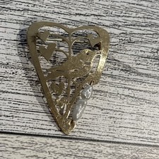 vintage metal brooch pin featuring a bird and leaves within an open heart frame