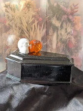 Witchy black coffin trinket box with skulls to help you open it.