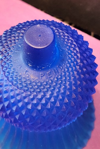 Cobalt blue glass tulip-shaped votive candle holder with textured diamond pattern, made in the USA on pink surface.