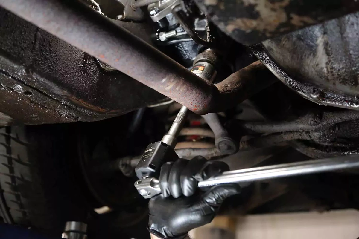 A ratchet wrench and torque gauge tighten the pitman arm nut to the recommended torque specifications.