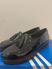 Image of Shiny black FitFlop tassel loafers with cushioned soles and sleek patent look