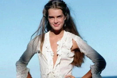 Brooke Shields in zerrissenem weißen Kleid posiert am Strand The Blue Lagoon