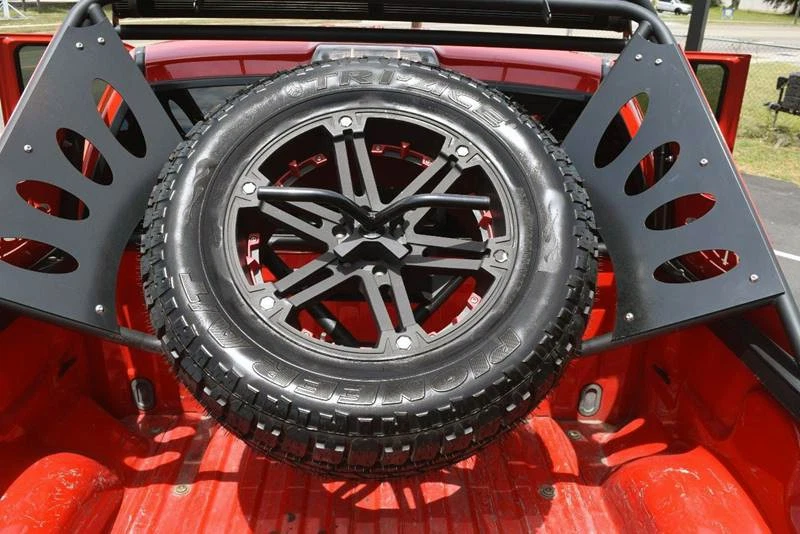 Cargo bed mounted spare tire storage on a 2013 Ford F-150 Raptor.
