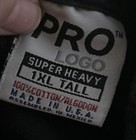 White fabric tag on black shirt with red “PRO LOGO” text, black “1XL Tall” label, and blue “Made in U.S.A.”