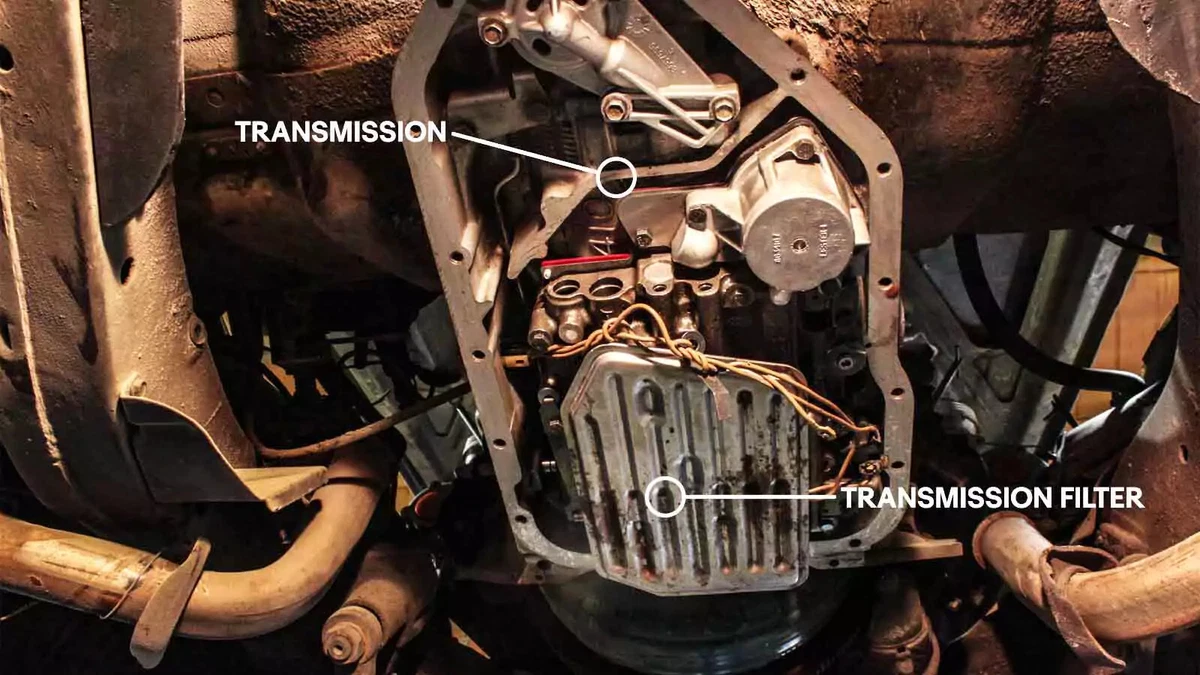 An annotated photo shows the transmission filter location with the drain pan removed.