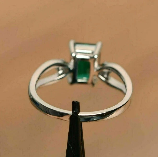 Anillo de tres piedras de moissanita blanca y esmeralda verde simulada en platino 950 Foto 2 de 4