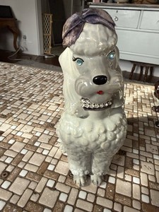 A decorative ceramic poodle figurine with a rhinestone collar Coin Bank