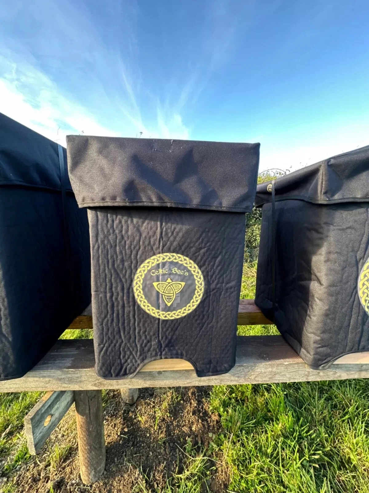 Celtic Beehive thermal winter jacket and waterproof roof hat fitted on a British National beehive outdoors