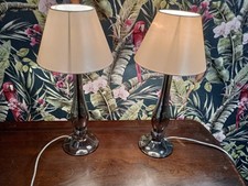 A Pair Of Dark Glass Table Lamps. Beige Coloured Shades.