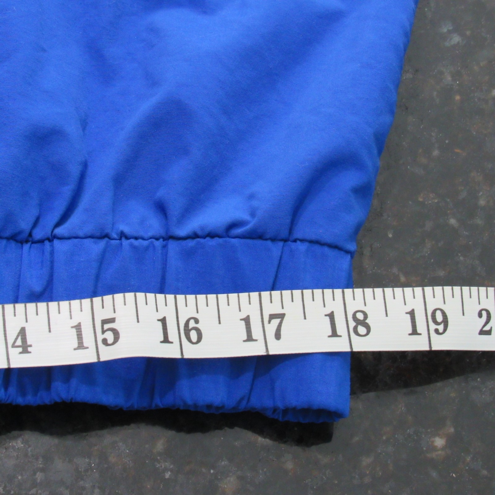 Blue vintage 90s Polo Sport Ralph Lauren jacket with white cuff, shown beside a measuring tape in inches.