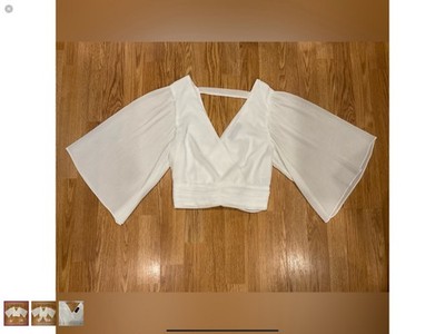 This is a white top with pleated bell sleeves