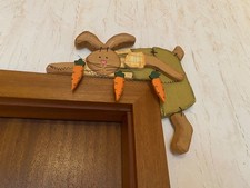 Osterhase aus holz sitzt dekorative auf dem Türrahmen