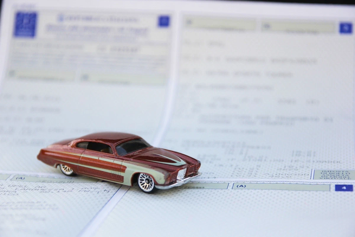 Die cast custom car on vehicle registration paperwork.