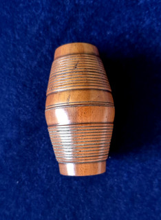 A good 19thC turned walnut nutmeg grater simulating a willow bound barrel.