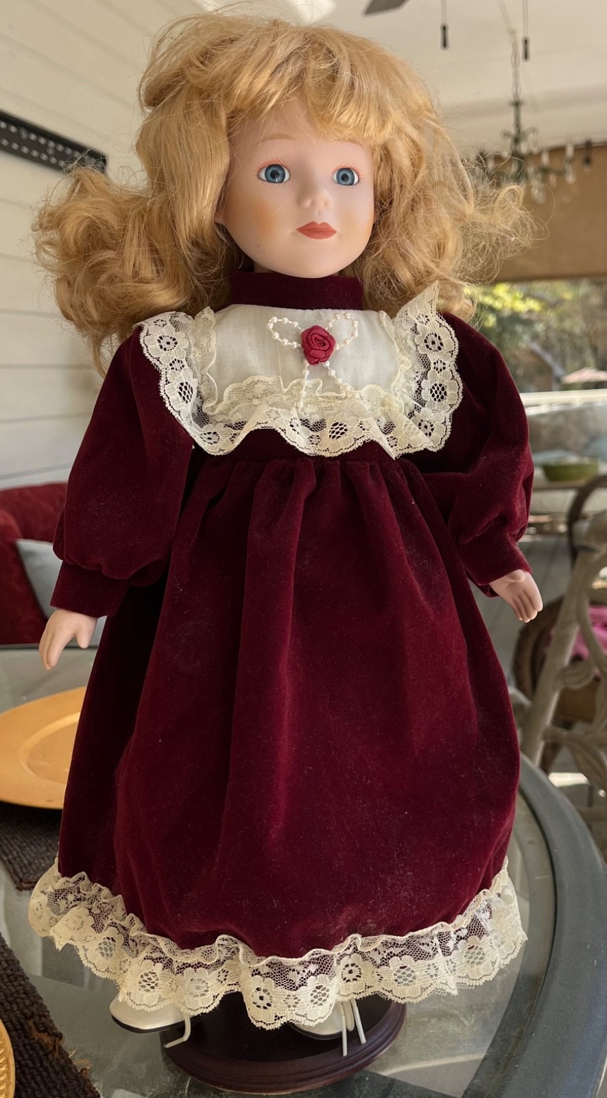 Beautiful , blonde porcelain doll on a wooden stand with Burgundy dress!