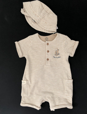 Kleine Jungen in einem Beigestreifen Strampler und Mütze 6/9 Monate