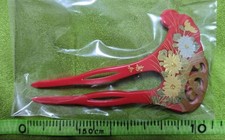 Unused plastic hairpin with floral pattern on red background