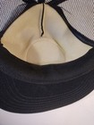 Black trucker hat with tan interior lining, snapback closure, and “Made in USA” text on the side.