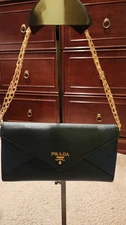 Prada Saffiano leather envelope wallet in blue with gold-tone hardware.