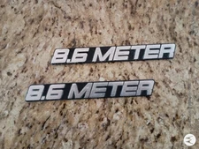 Trojan port and starboard 8.6 Meter Express emblems. Good Condition 