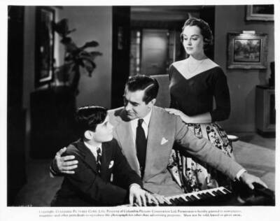 Tyrone Power plays piano with a boy as Victoria Shaw watches The E- Old Photo