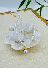 Collier perles synthétiques avec un pendentif en perle surmontée d'une fleur en