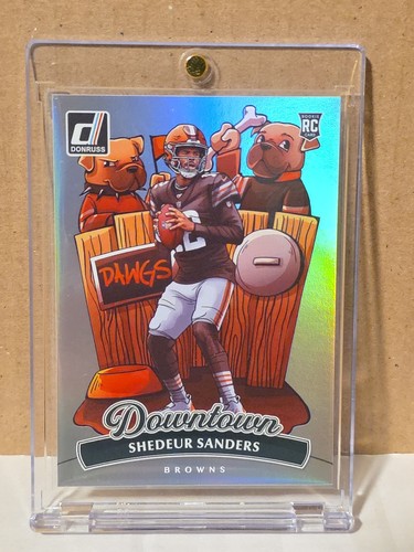2025 Panini Donruss Downtown #17 Shedeur Sanders card, Browns uniform, cartoon bench, RC SSP case.