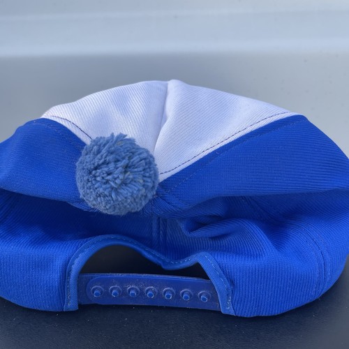 Blue and white vintage snapback pom hat with light blue top and embroidered white brim text reading “Leading for Tomorrow.”