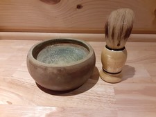 Vintage shaving brush with a wooden handle and a matching ceramic shaving bowl.