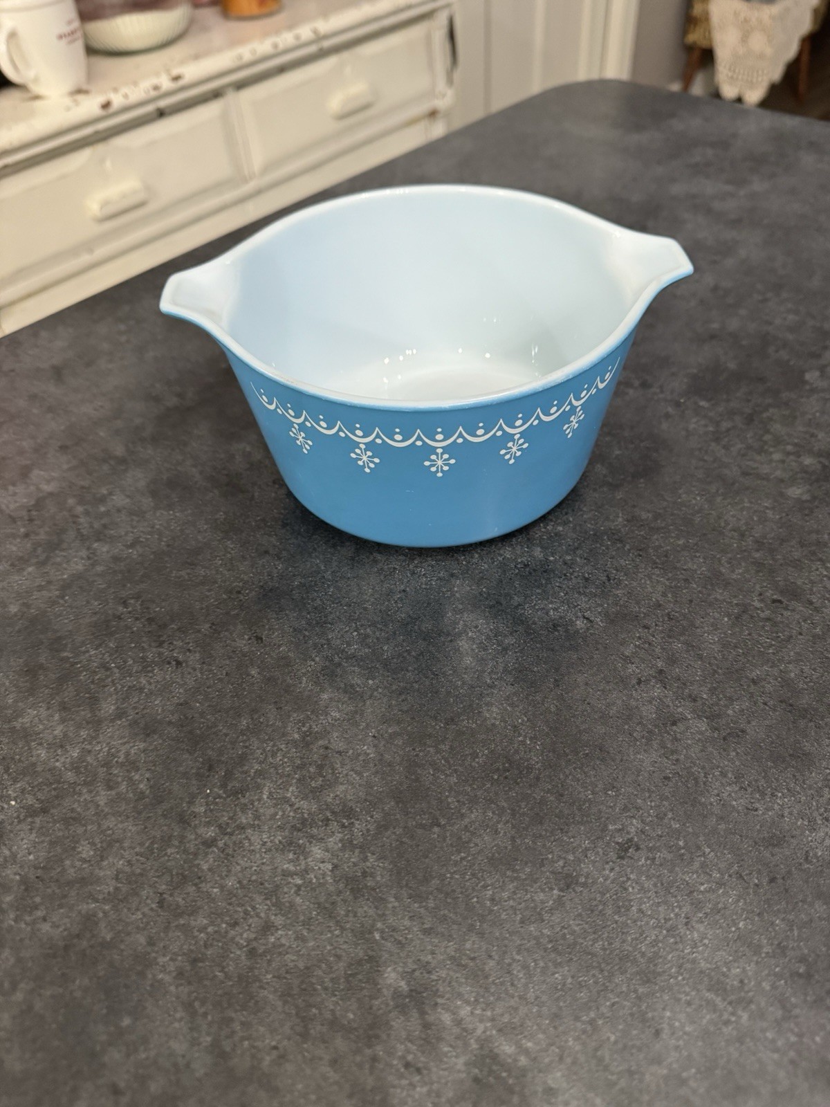 Blue and white Pyrex casserole dish with a snowflake garland pattern