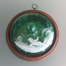 ANTIQUE MARY GREGORY GREEN GLASS LID MOUNTED ON WOODEN FRAME FOR WALL DISPLAY.