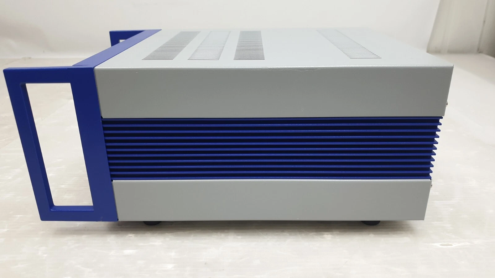 Side of the PI E-501K005 chassis with blue heatsink fins and carry handle