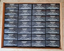 Black rectangular Creed Aventus boxes with white text, arranged in a 4x4 grid inside a larger brown cardboard box.