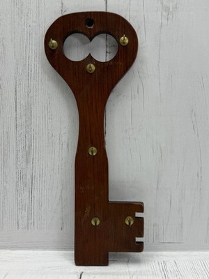 vintage wooden key holder features six brass hooks for organization.