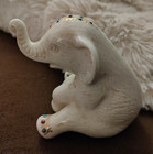 White Porcelain Elephant Figurine Seated Trunk Up, Floral & Jeweled Accents — photo 1