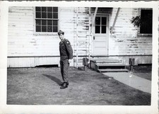 WW2 Photo of Soldier Standing in Front of Wooden Barracks