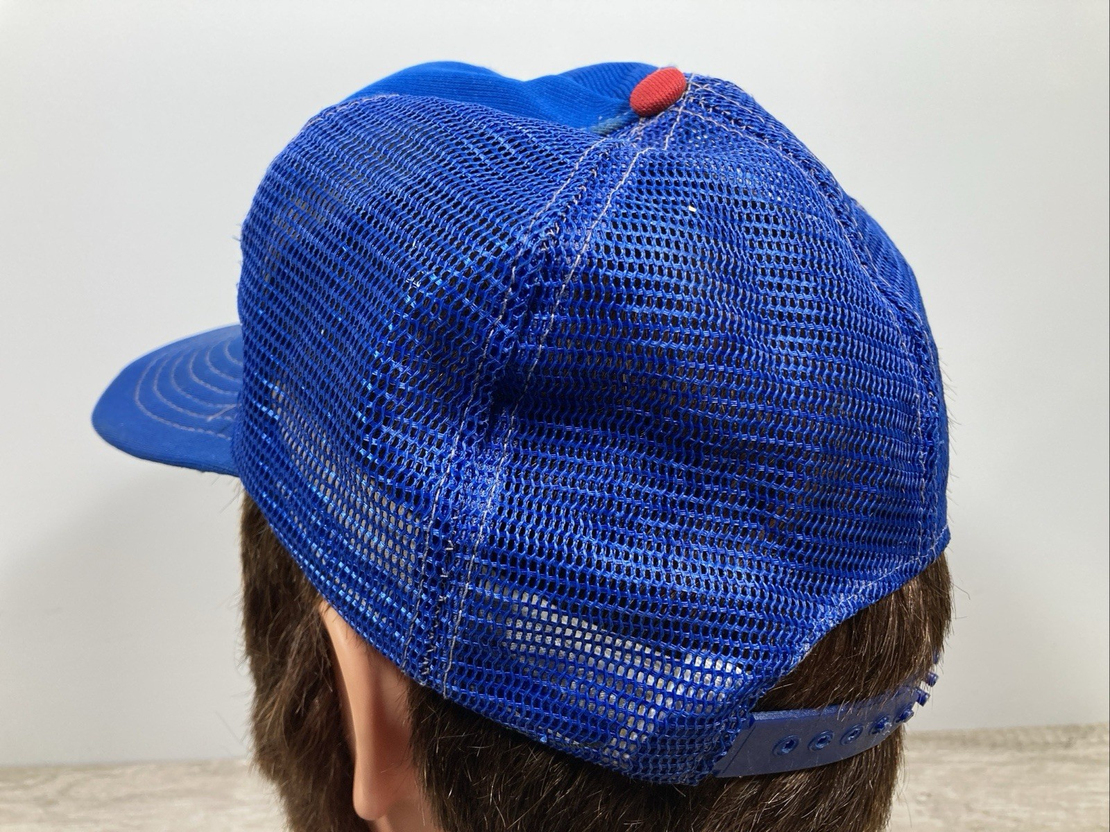 Blue mesh baseball trucker hat with red and white stripe, embroidered “VTG Chicago Cubs” text in white and blue on the back.
