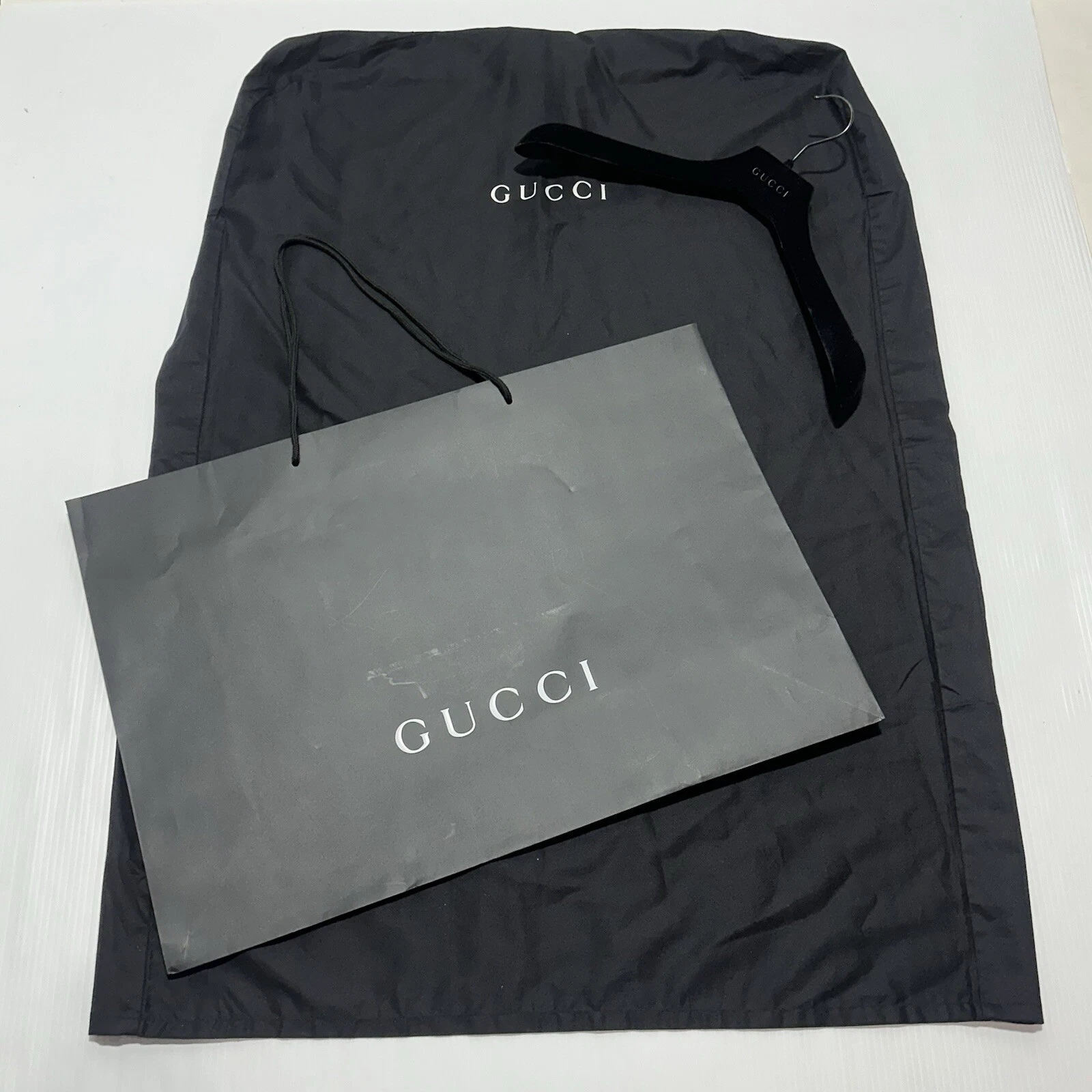 Gucci Lot de 3 protections pour vêtements + cintre noir + sac en papier shopping noir