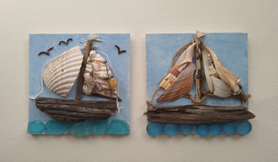 Two Seashell and driftwood sailboats each on its own 5'' square painted canvas.
