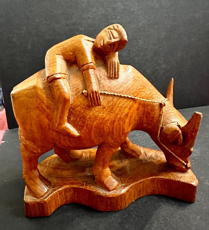 Vintage Hand carved wooden person resting or sleeping on a water buffalo or ox