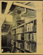 1986 Press Photo Worker Cleaning Top of Library Shelf with Vacuum - lrb37861
