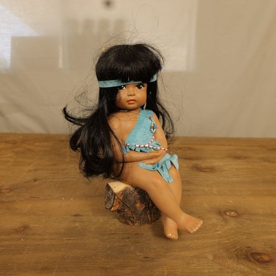 Indianer sitzende Puppe schwarze Haare blau Wildleder Outfit Perlen Feder Stirnband