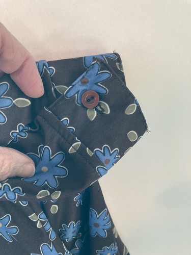 Black County Seat ladies shirt size M with blue and yellow flower print, buttoned cuff, and “Made in USA” label.