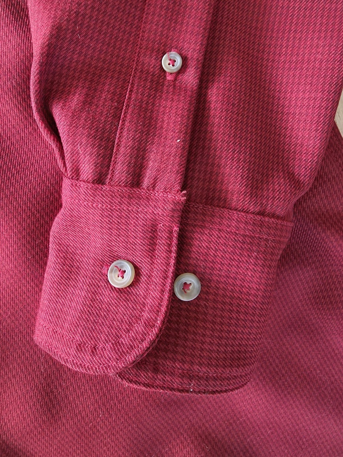 Filson virgin wool guide shirt with long sleeves, button front, and two white buttons on the cuffs.