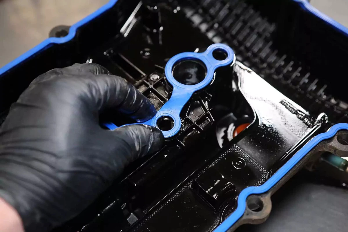 Mechanic installing a blue spark plug seal.
